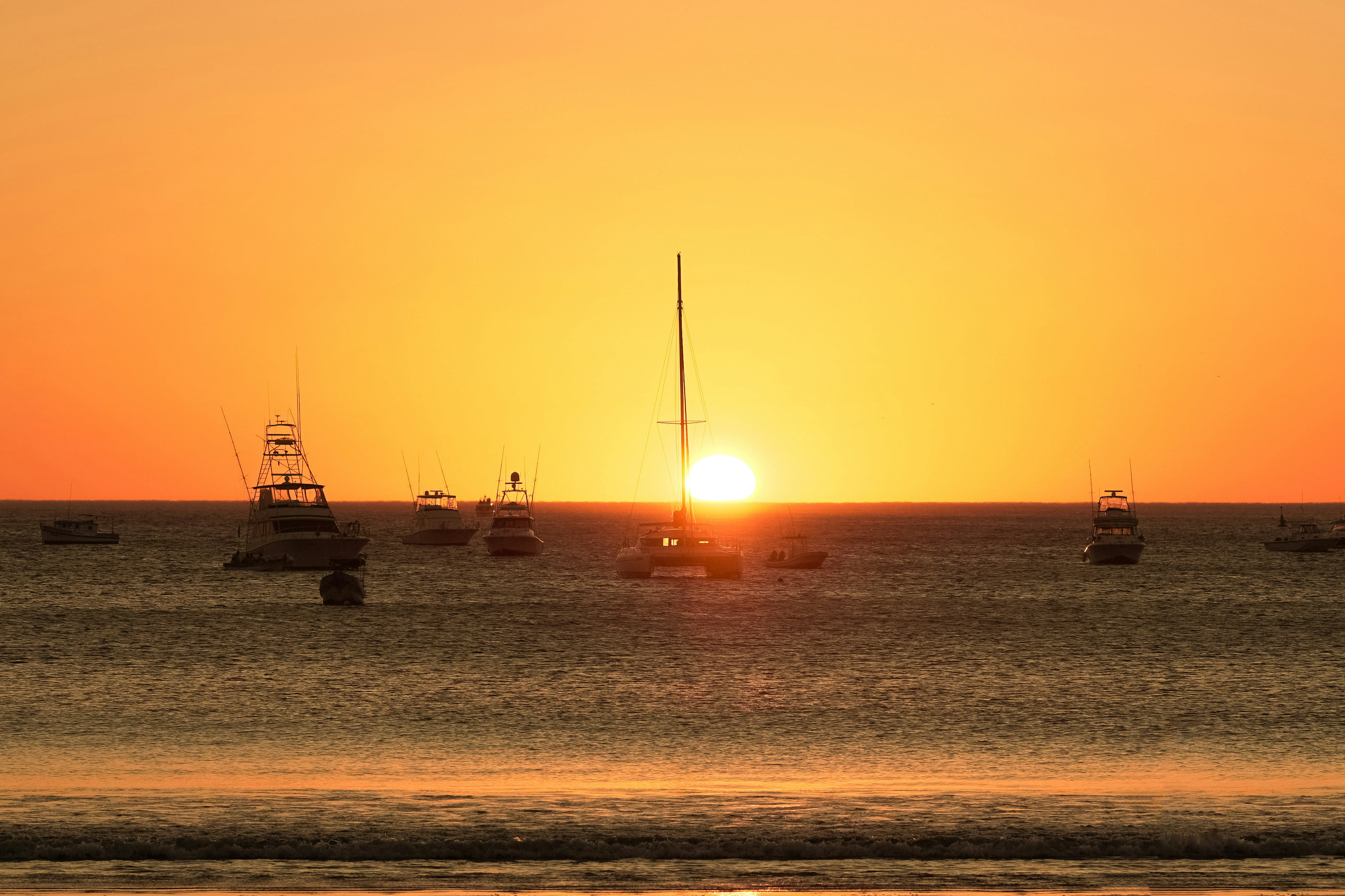 silhouette of boat on sea during sunset