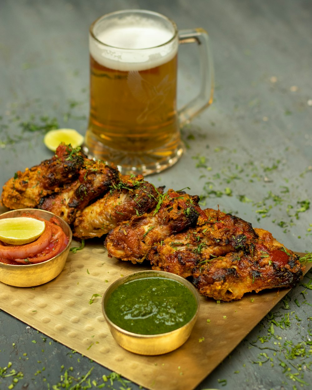 grilled meat on white ceramic plate beside clear glass mug with beer