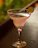 A stylish cocktail glass filled with a bright, refreshing drink garnished with a slice of lime.