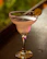 A stylish cocktail glass filled with a bright, refreshing drink garnished with a slice of lime.