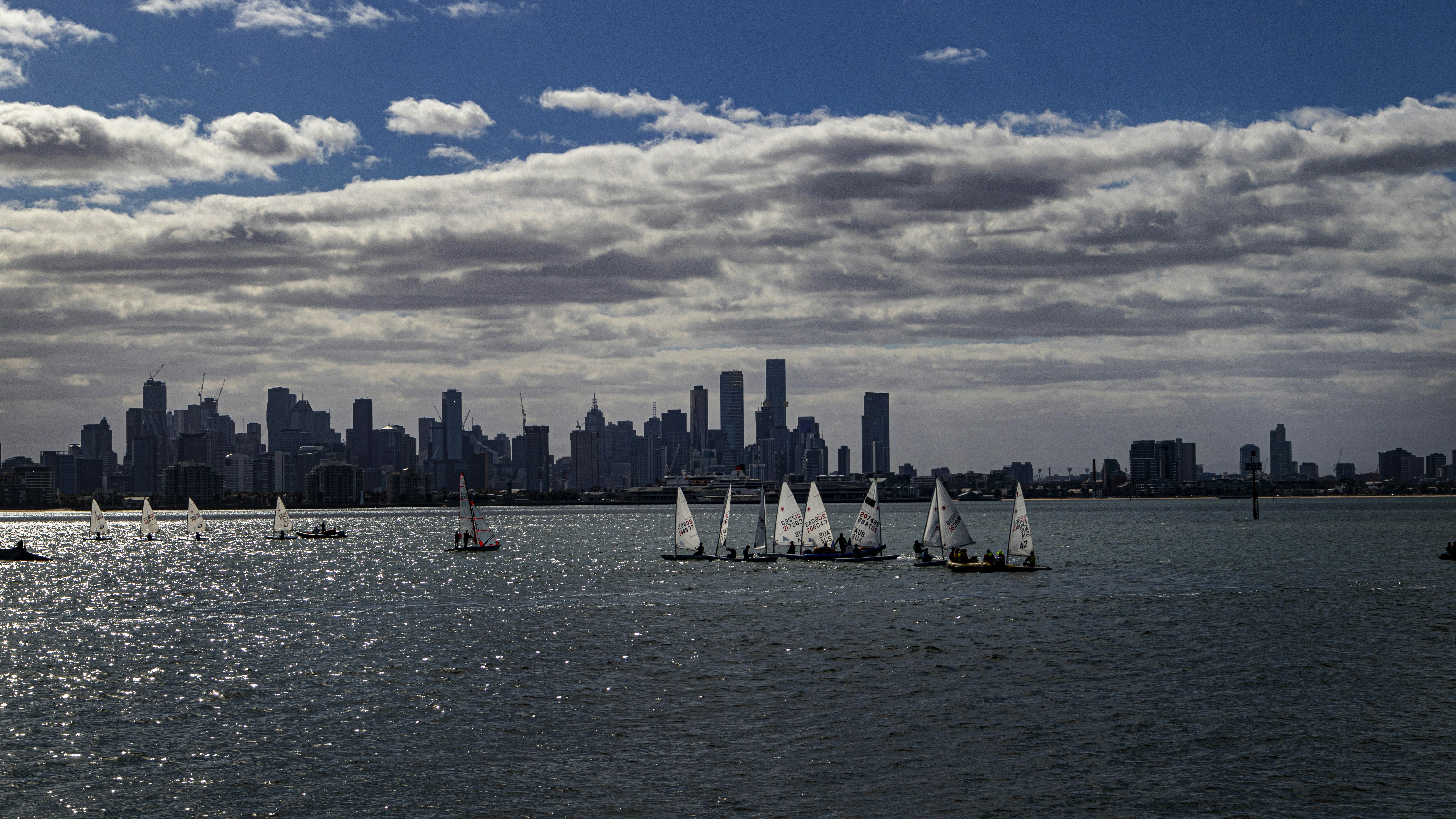 white sail boat on sea under blue sky and white clouds during daytime