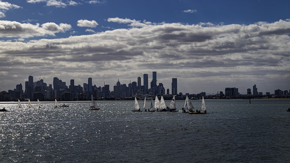 white sail boat on sea under blue sky and white clouds during daytime