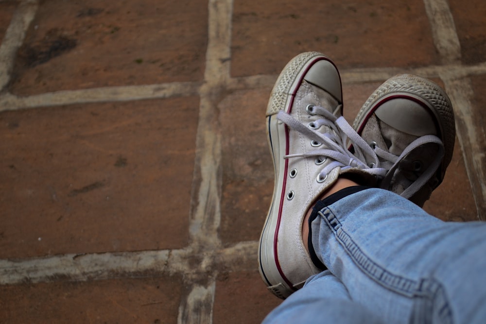 person wearing blue denim jeans and gray and white sneakers