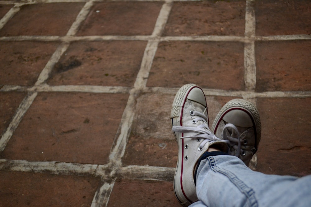 person in blue denim jeans and white sneakers