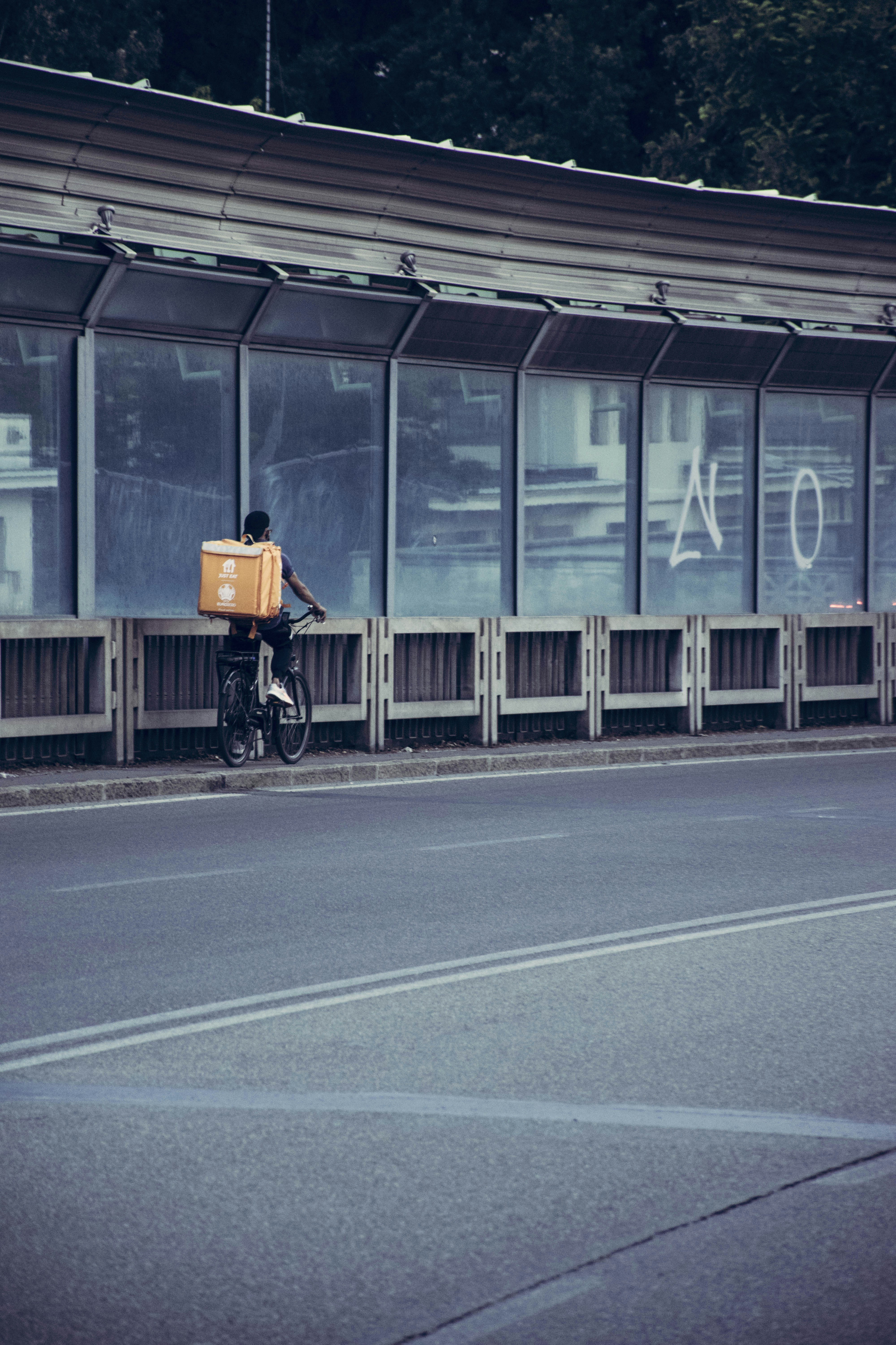 man in black jacket riding bicycle on road during daytime