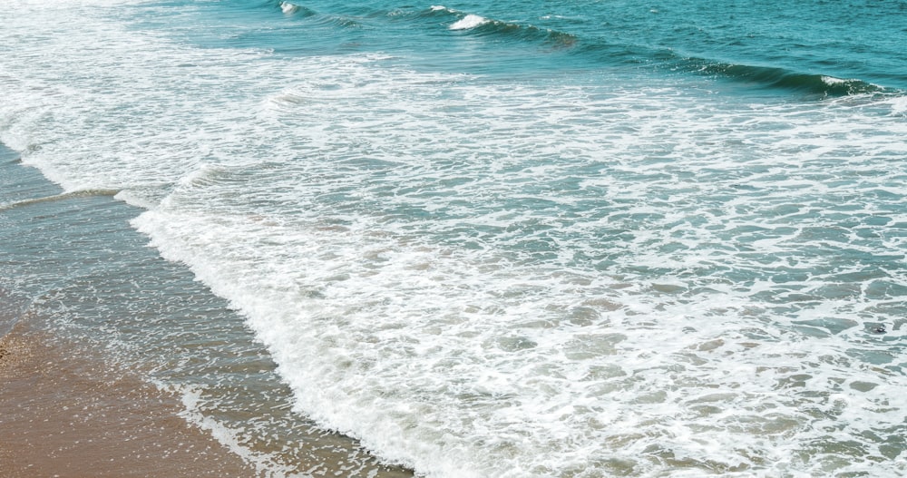 sea waves crashing on shore during daytime