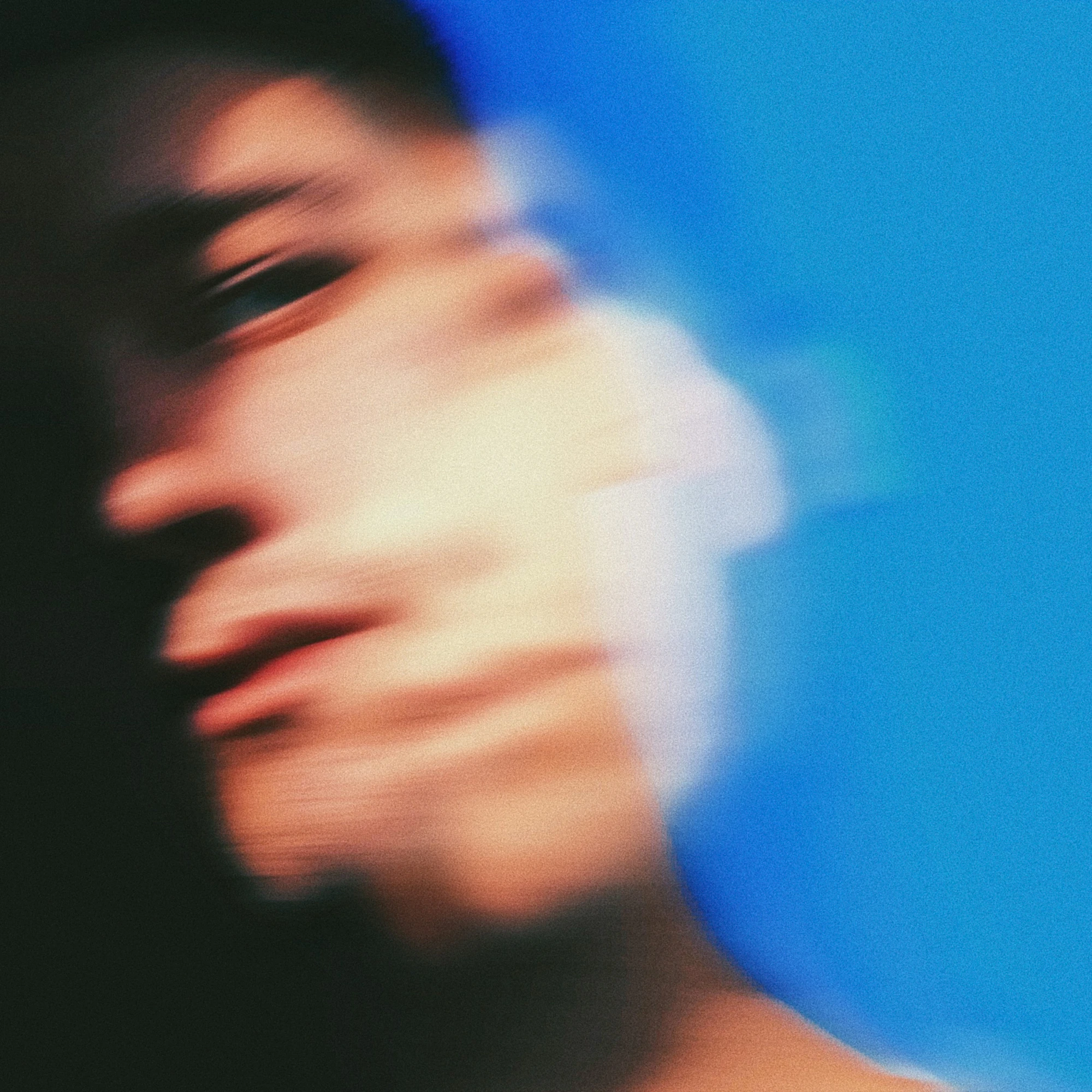 A motion-blurred portrait against a deep blue background