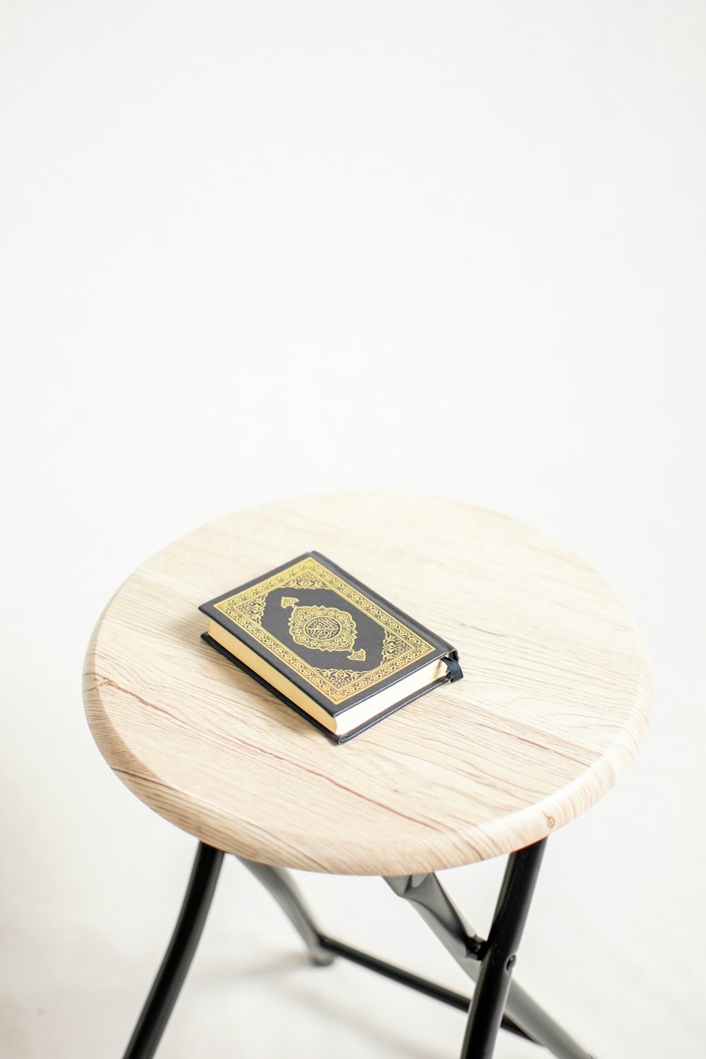 black and gold book on brown wooden seat