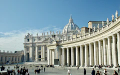 people walking around white concrete building during daytime