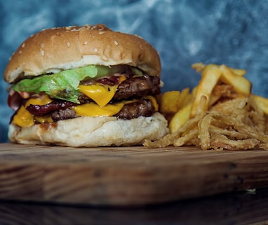 burger with lettuce and fries on brown wooden table