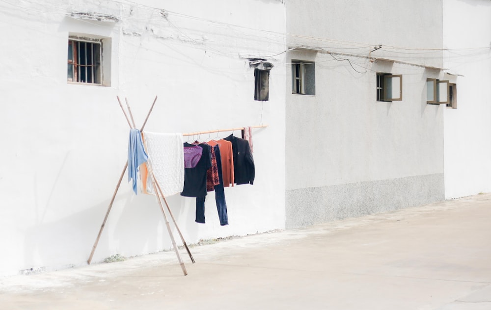 Kleidung hängt tagsüber an einer Wäscheleine in der Nähe eines weißen Betongebäudes