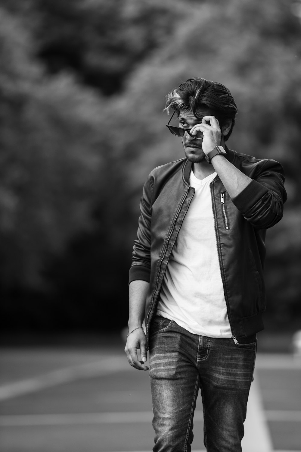 grayscale photo of man in jacket and denim jeans