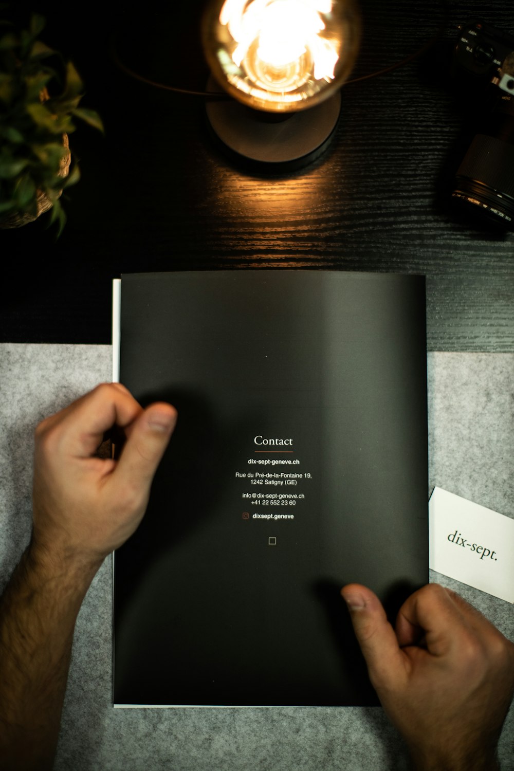 person holding black book on black table