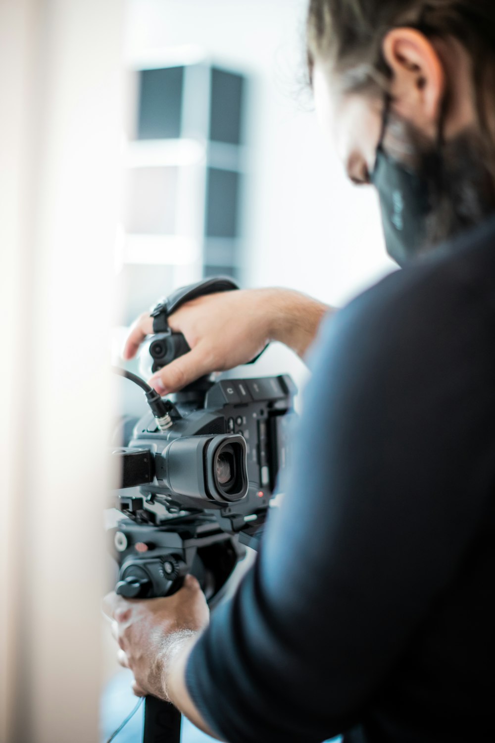 man in black shirt holding black dslr camera