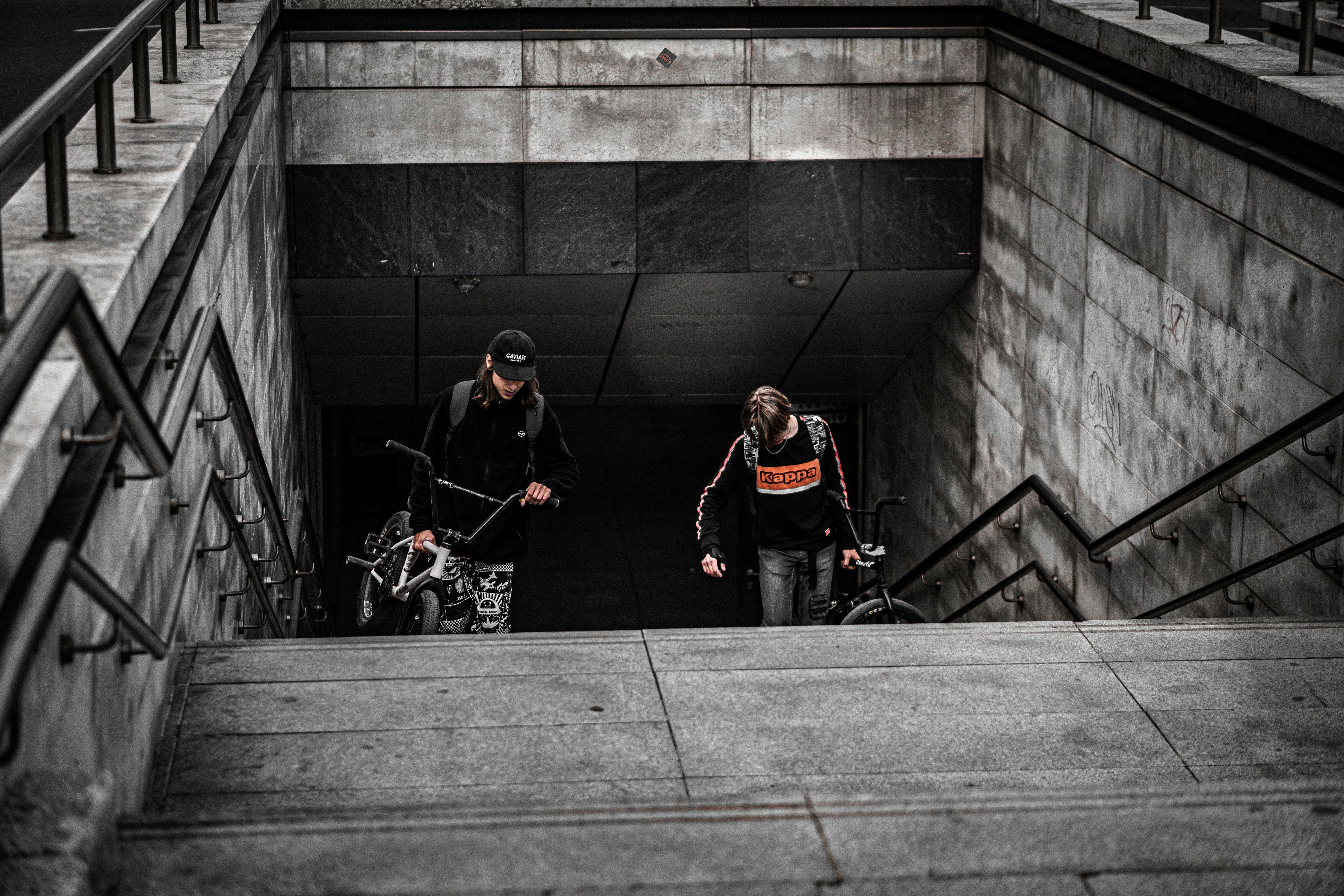 man in black jacket and black pants standing beside black bicycle