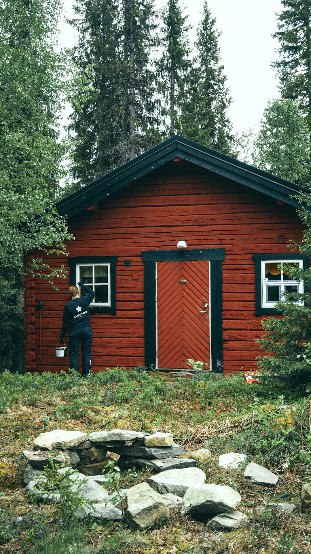 a professional painter painting a small cottage style house