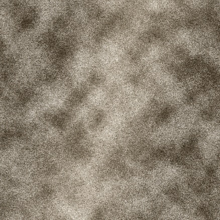 A textured surface with a speckled or grainy pattern, containing varying shades of gray and brown. The distribution of colors creates a camouflage or noise-like effect.