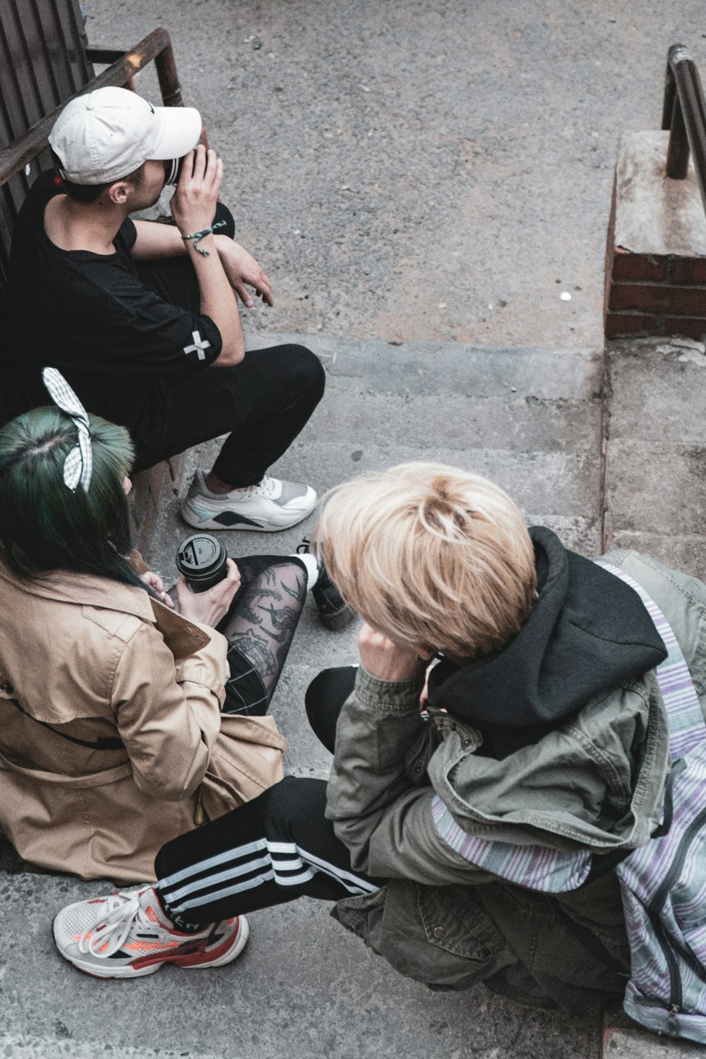 woman in brown jacket sitting on concrete stairs