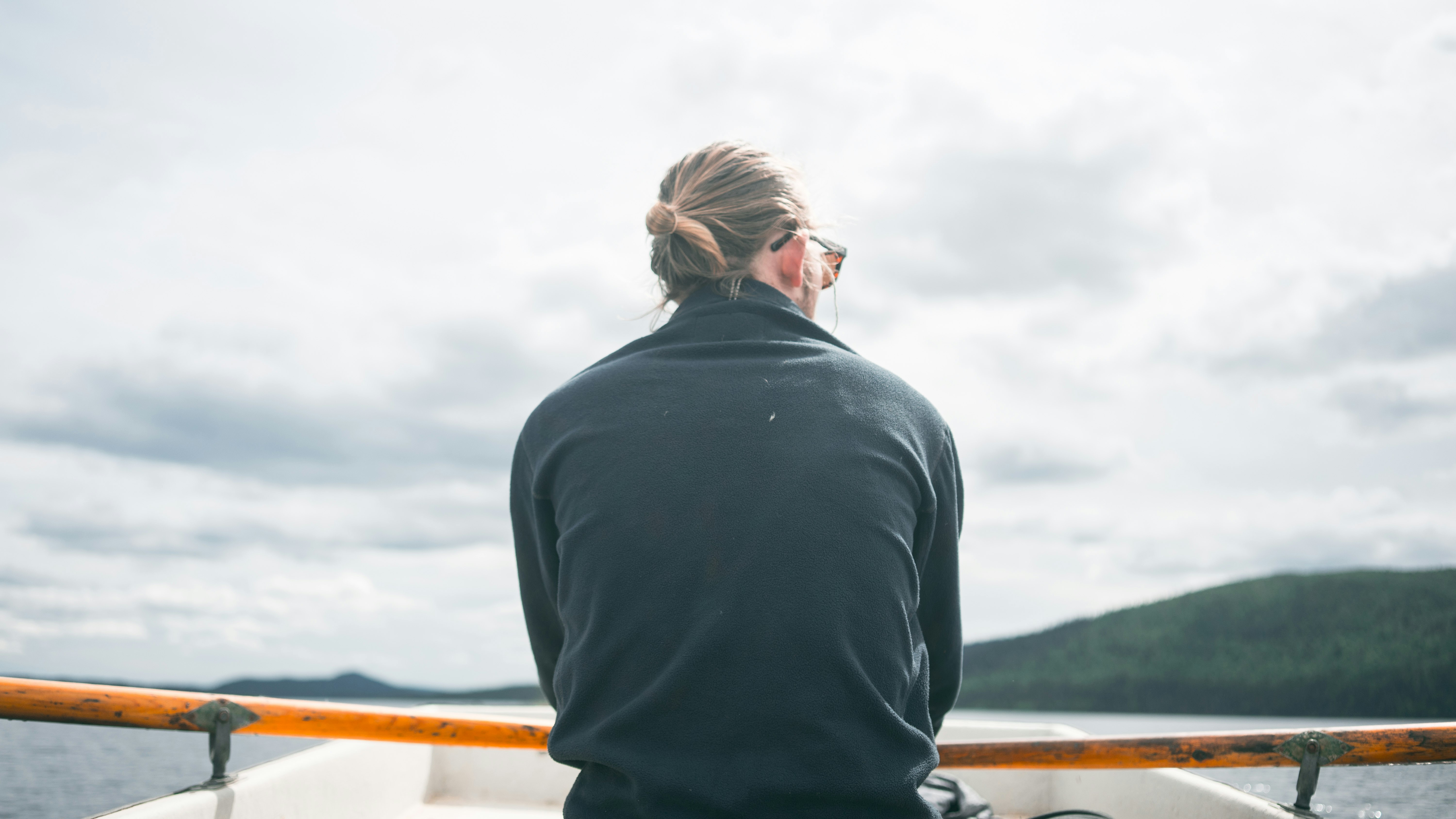 man in black long sleeve shirt standing on brown wooden dock during daytime