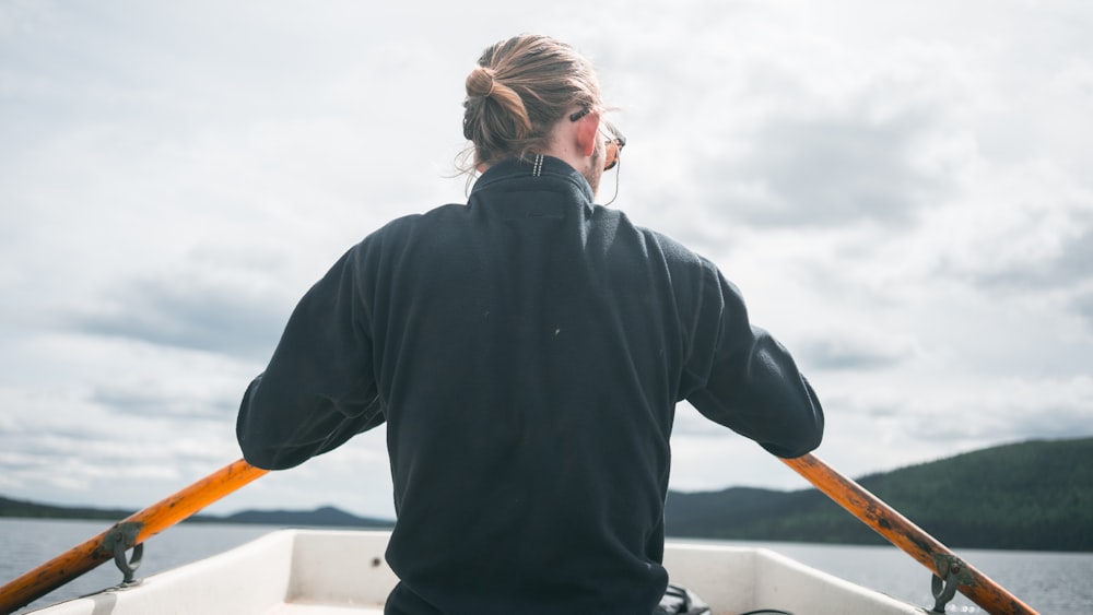 woman in black jacket standing on boat during daytime