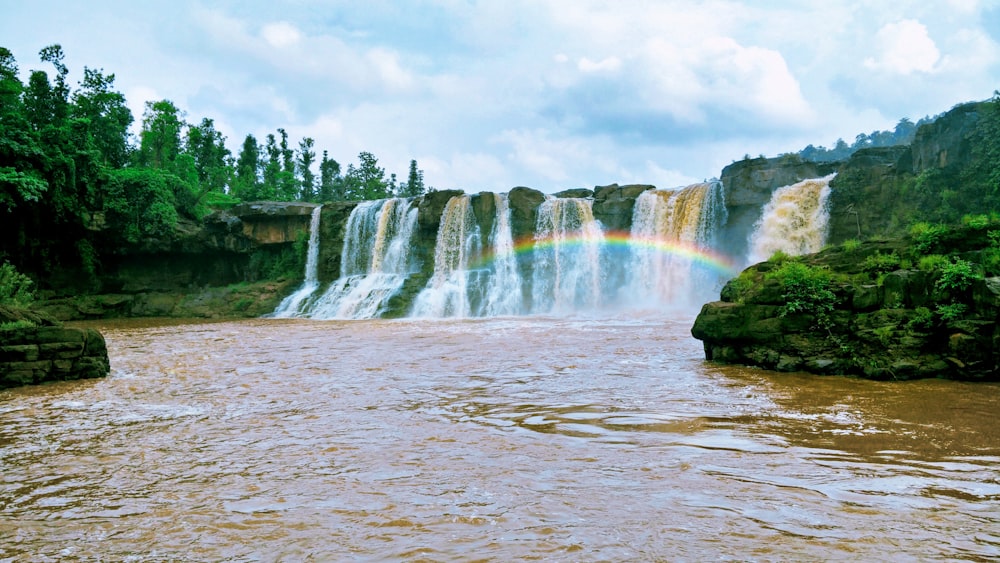 waterfalls under white cloudy sky during daytime