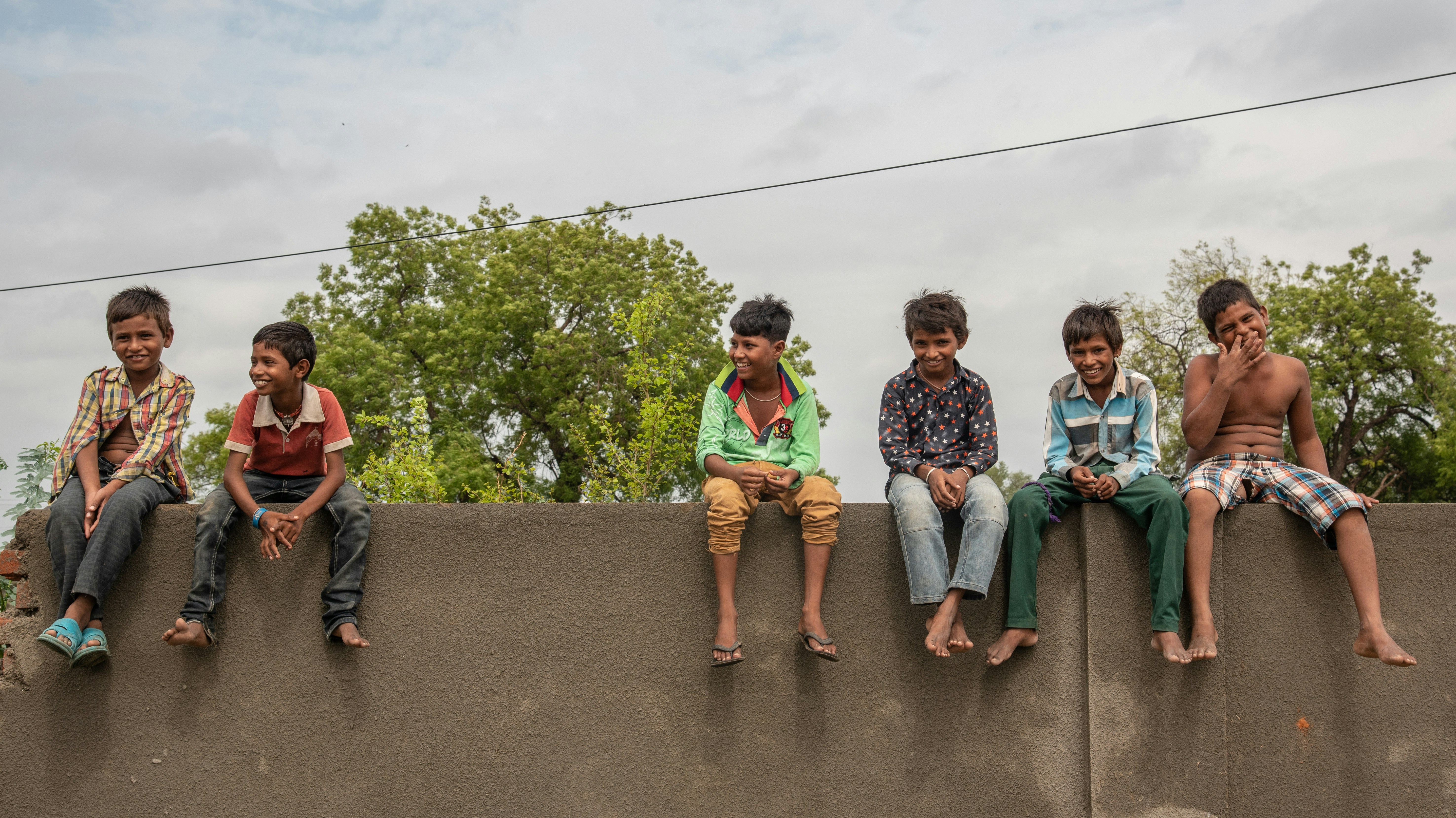 3 women sitting on concrete bench during daytime