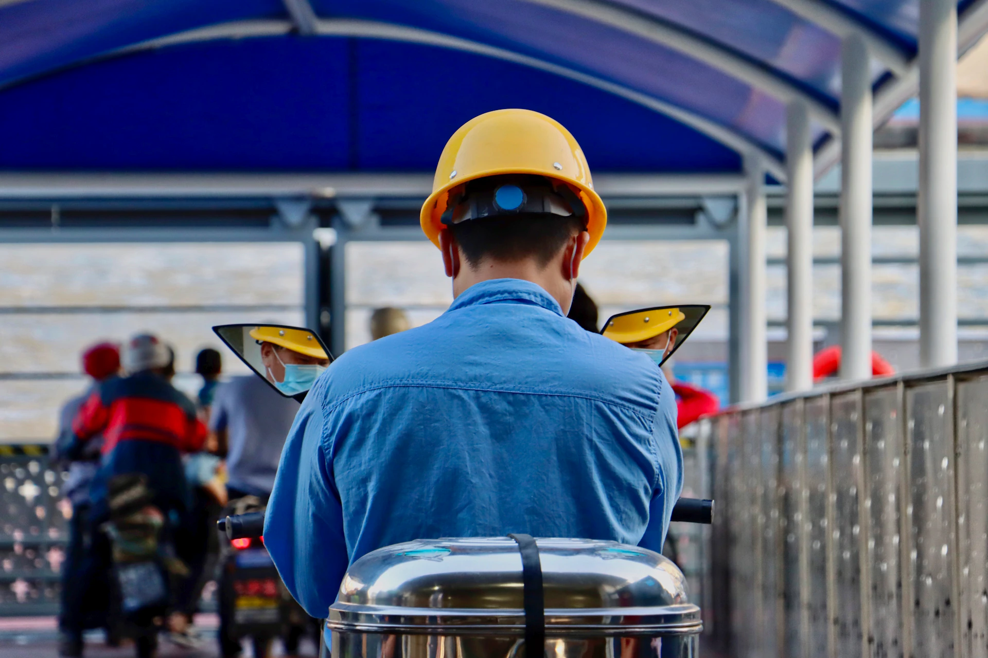 man in blue shirt wearing yellow hard hat