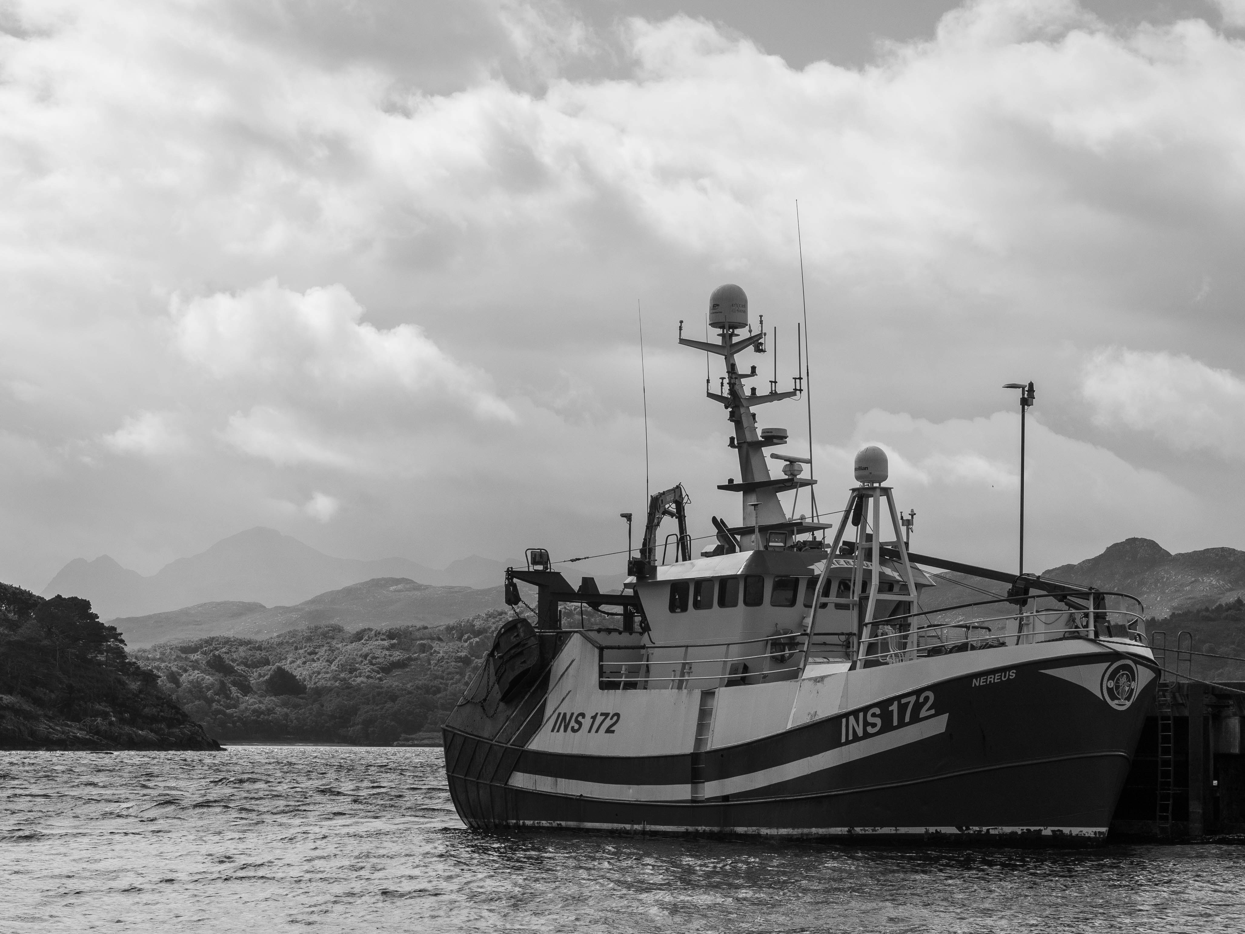 grayscale photo of people riding on boat on sea