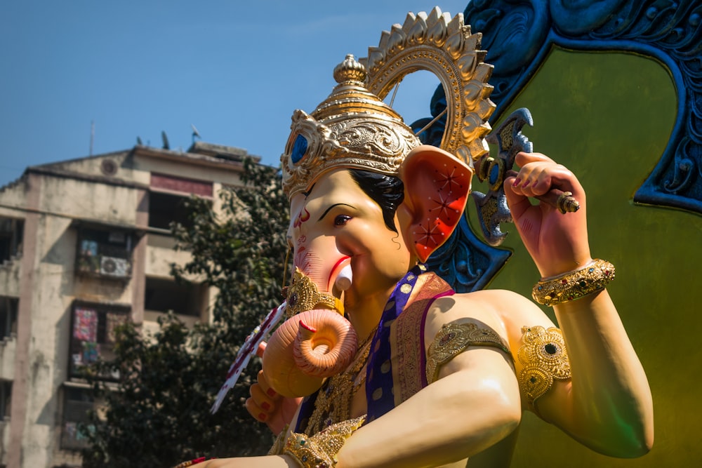 woman in gold and purple sari dress holding gold crown