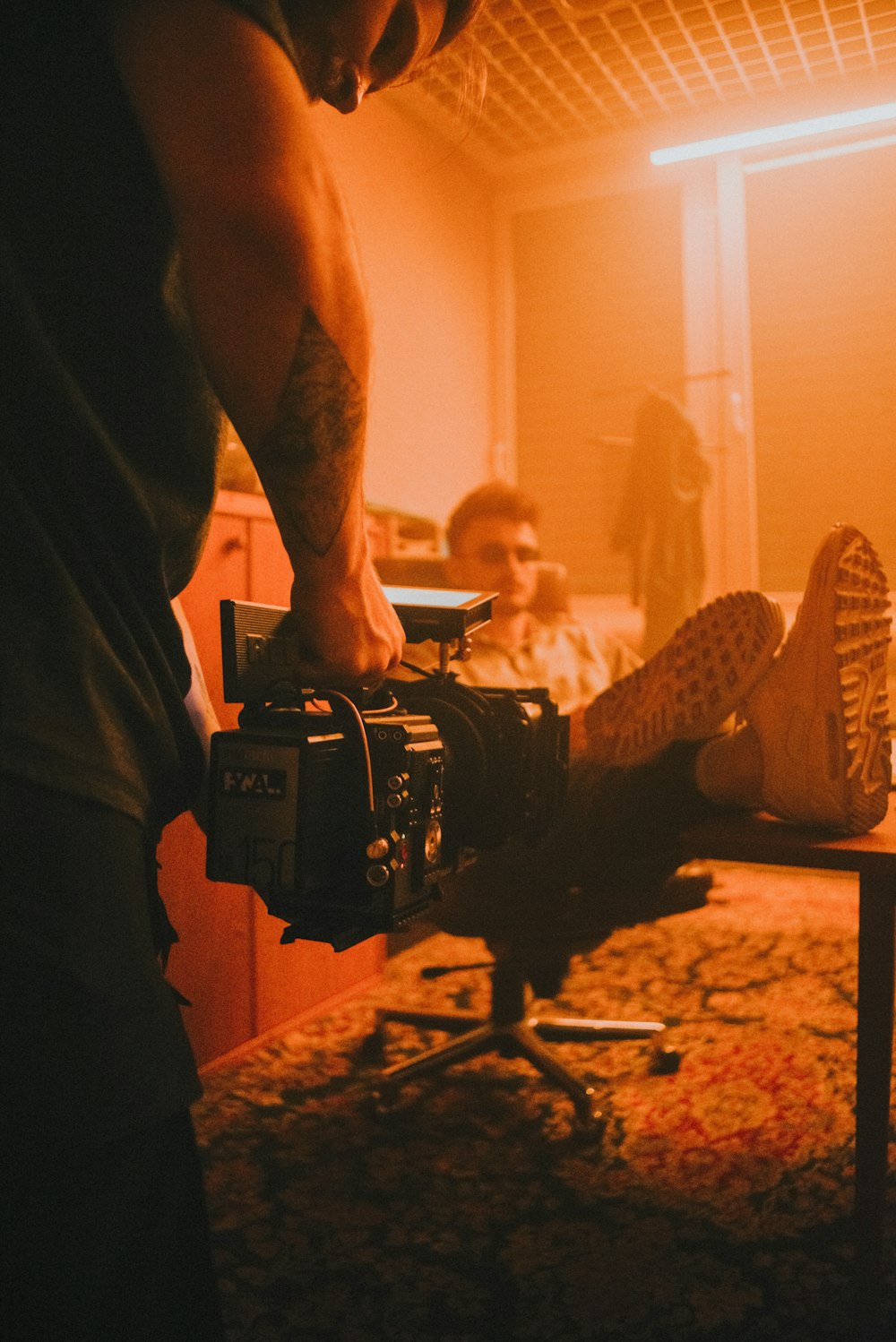 man in black shorts and black nike sneakers holding black video camera