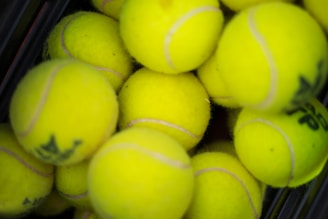 A close-up of colorful tennis balls arranged in a neat pattern on a wooden surface