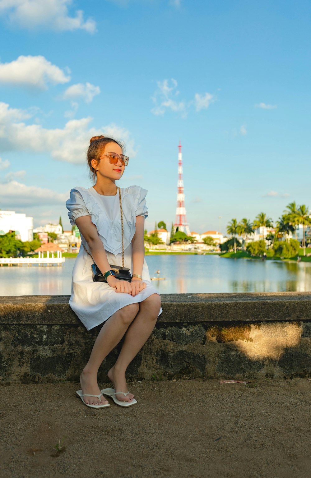 woman in white long sleeve shirt sitting on concrete bench