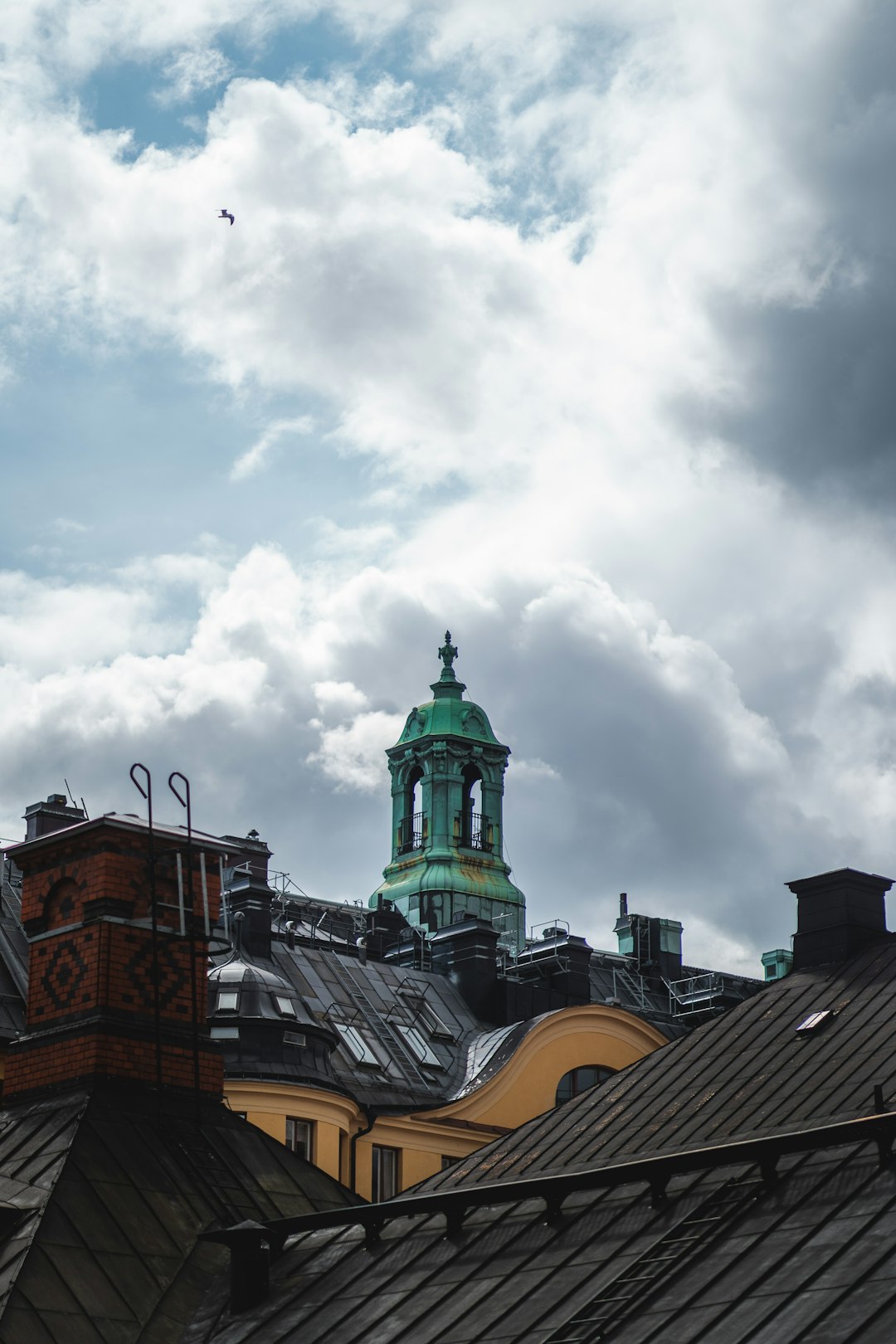 brown and green concrete building under white clouds