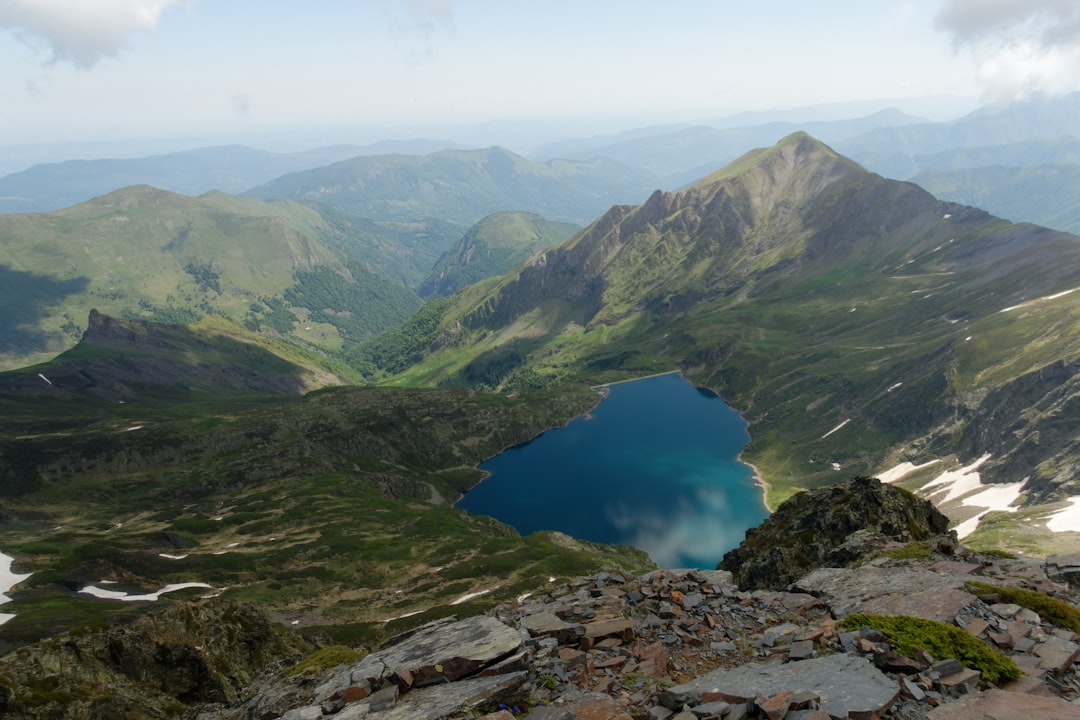 green mountains beside blue lake during daytime