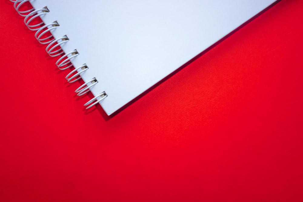 Cuaderno de espiral blanco sobre superficie roja