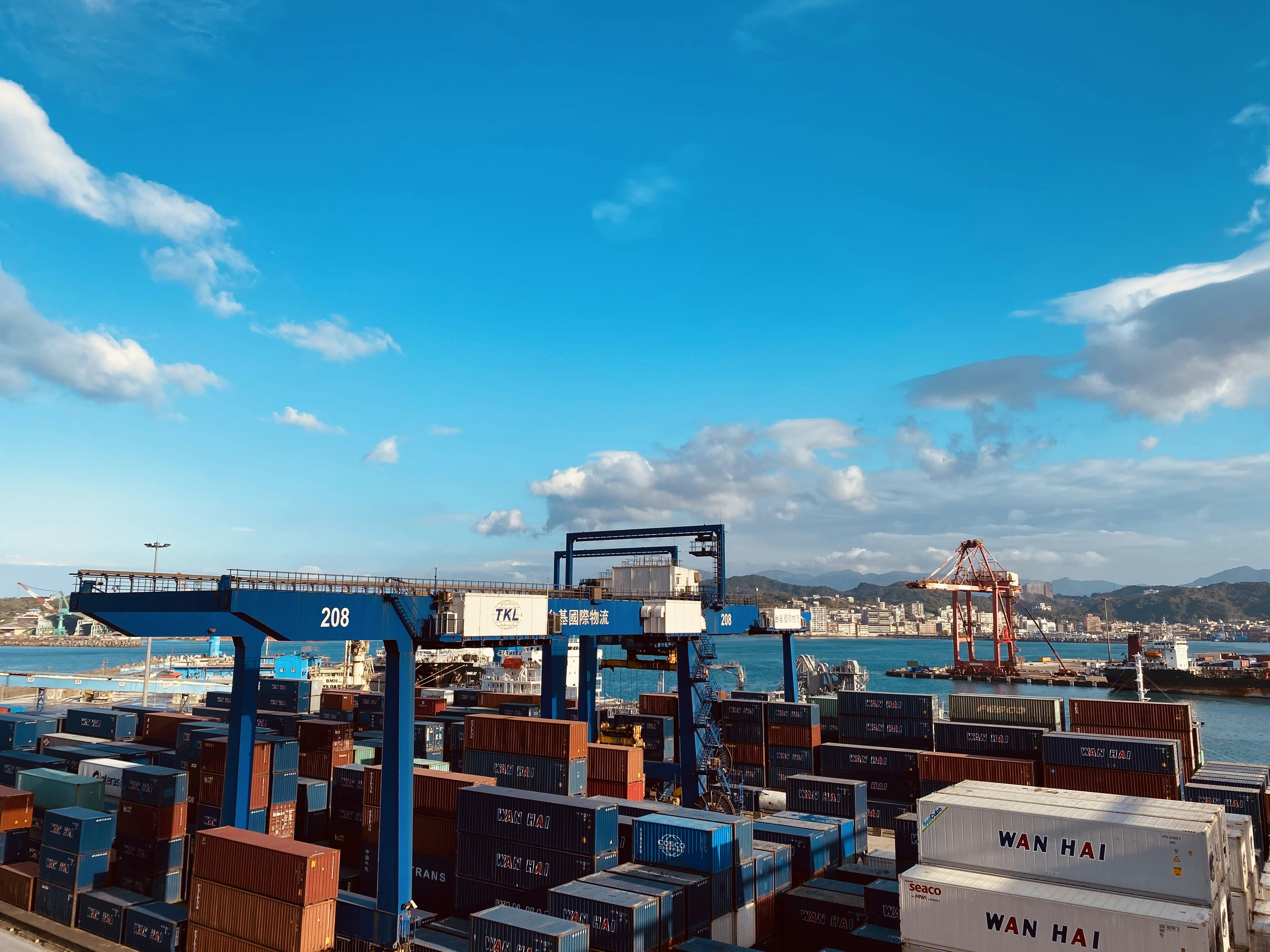 Cargo containers at a busy port facility in bright daylight, industrial logistics environment