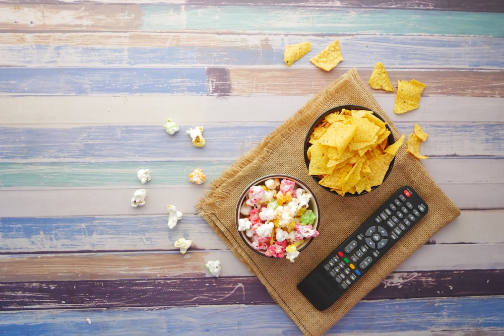 black remote control beside brown wooden chopping board