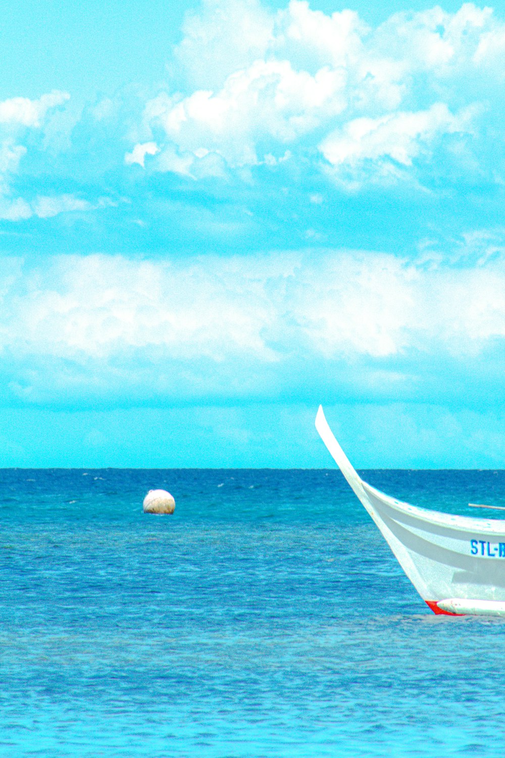 white and red boat on sea under blue sky during daytime