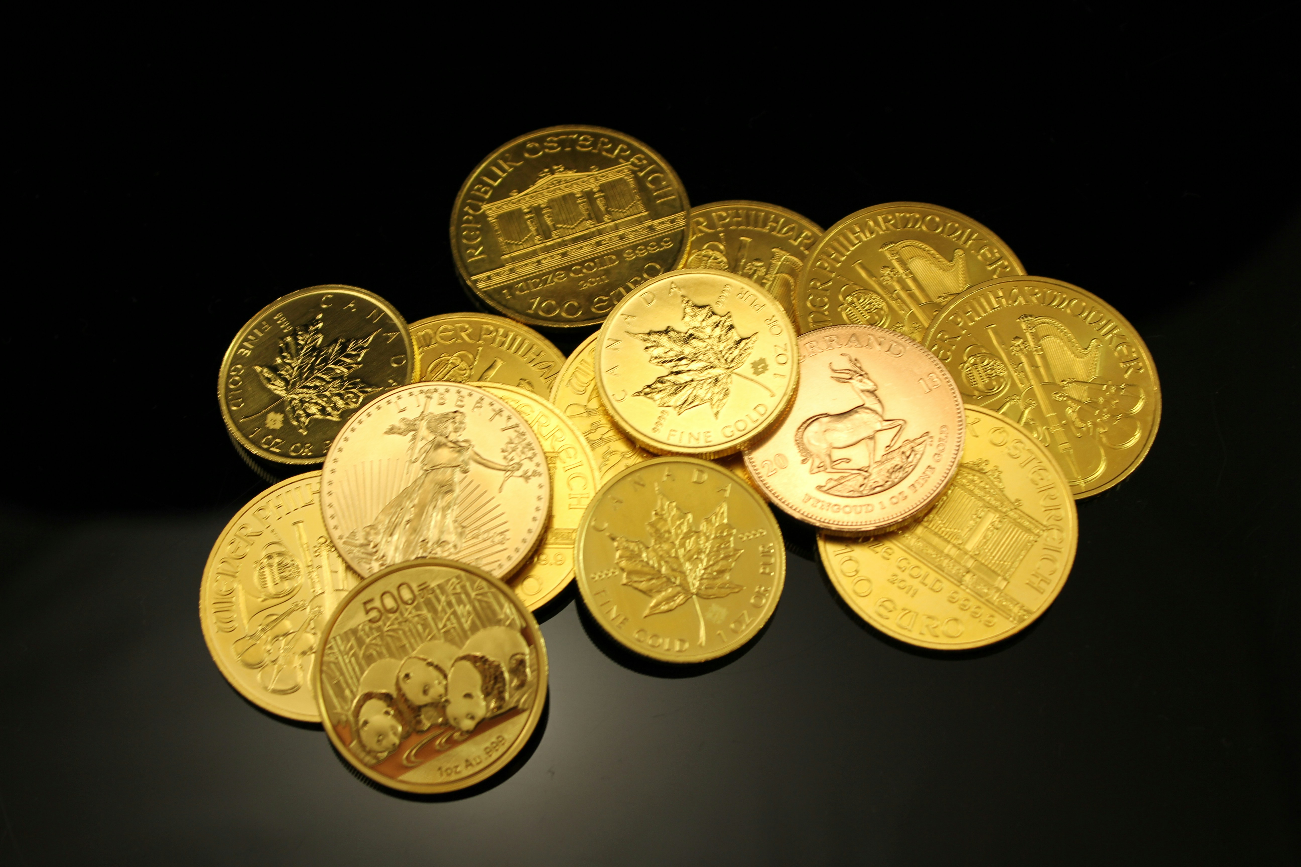 Pile of gold bullion coins. Münze Österreich, Royal Canadian Mint, U.S. Mint, Australian Mint of Perth, China Panda and Krugerrand. If you use our photos, please add credit to https://zlataky.cz, when possible