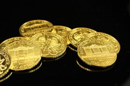 gold round coins on black surface