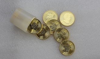 silver round coins on white surface
