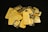 A pile of gold bars and coins scattered on a dark surface, featuring inscriptions and logos, some bars are stacked neatly while others are overlapping.