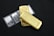 Several gold and platinum bars are arranged on a dark background. The gold bars have markings indicating 500g fine gold, while the platinum bars are marked as 1 ounce of fine platinum. The shiny metallic surfaces reflect light.