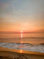 ocean waves crashing on shore during sunset