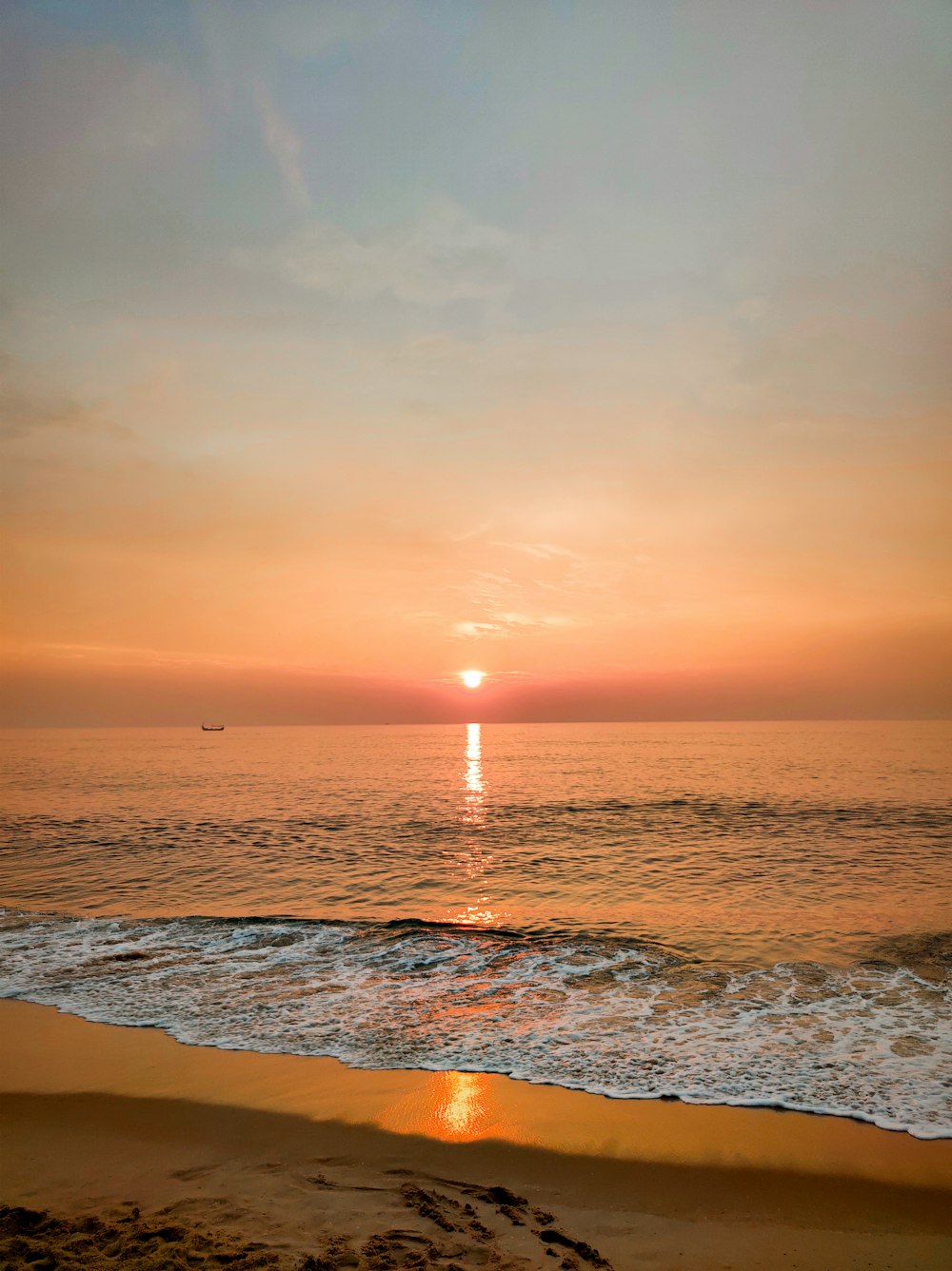 ocean waves crashing on shore during sunset