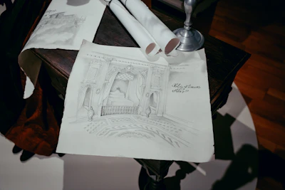 Close-up of a designer sketching a sophisticated interior layout with gold and black details.