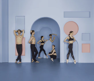 A diverse group of researchers and dancers collaborating in a bright, modern conference hall.