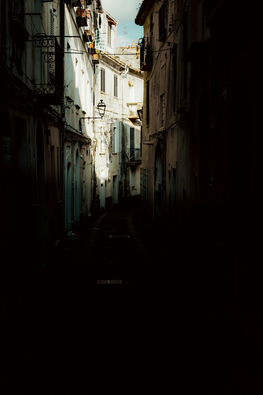 empty hallway between white concrete buildings during daytime