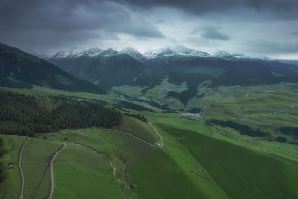 green grass field under white clouds during daytime