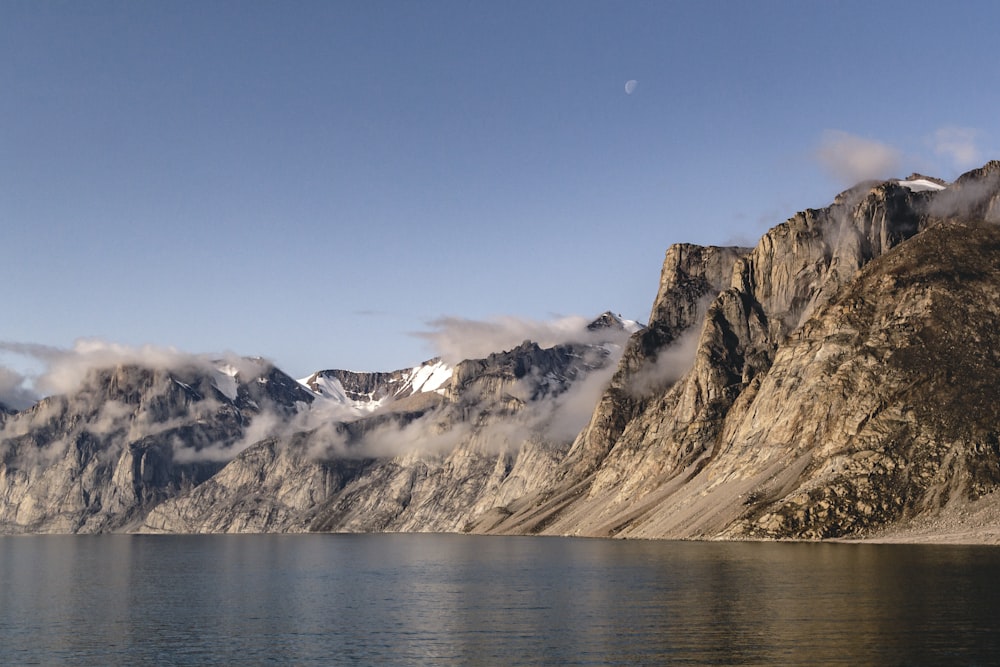 brown and white mountains near body of water during daytime